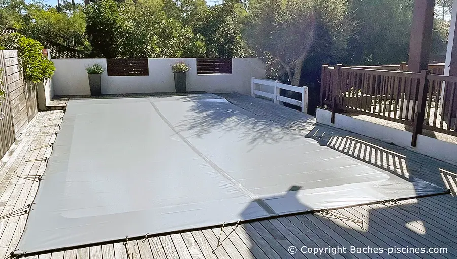Bâche d'hivernage opaque Bâches Piscines tendue sur une piscine enterrée, vue de trois quarts