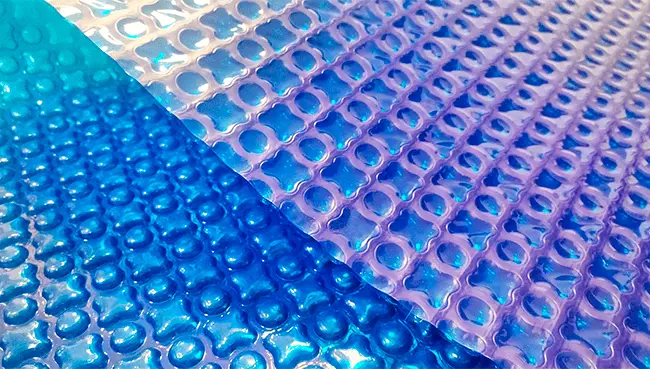 Bâche à bulles OXO Dark Blue 500 Bâches Piscines, un coin du film bleu foncé retourné sur ses bulles