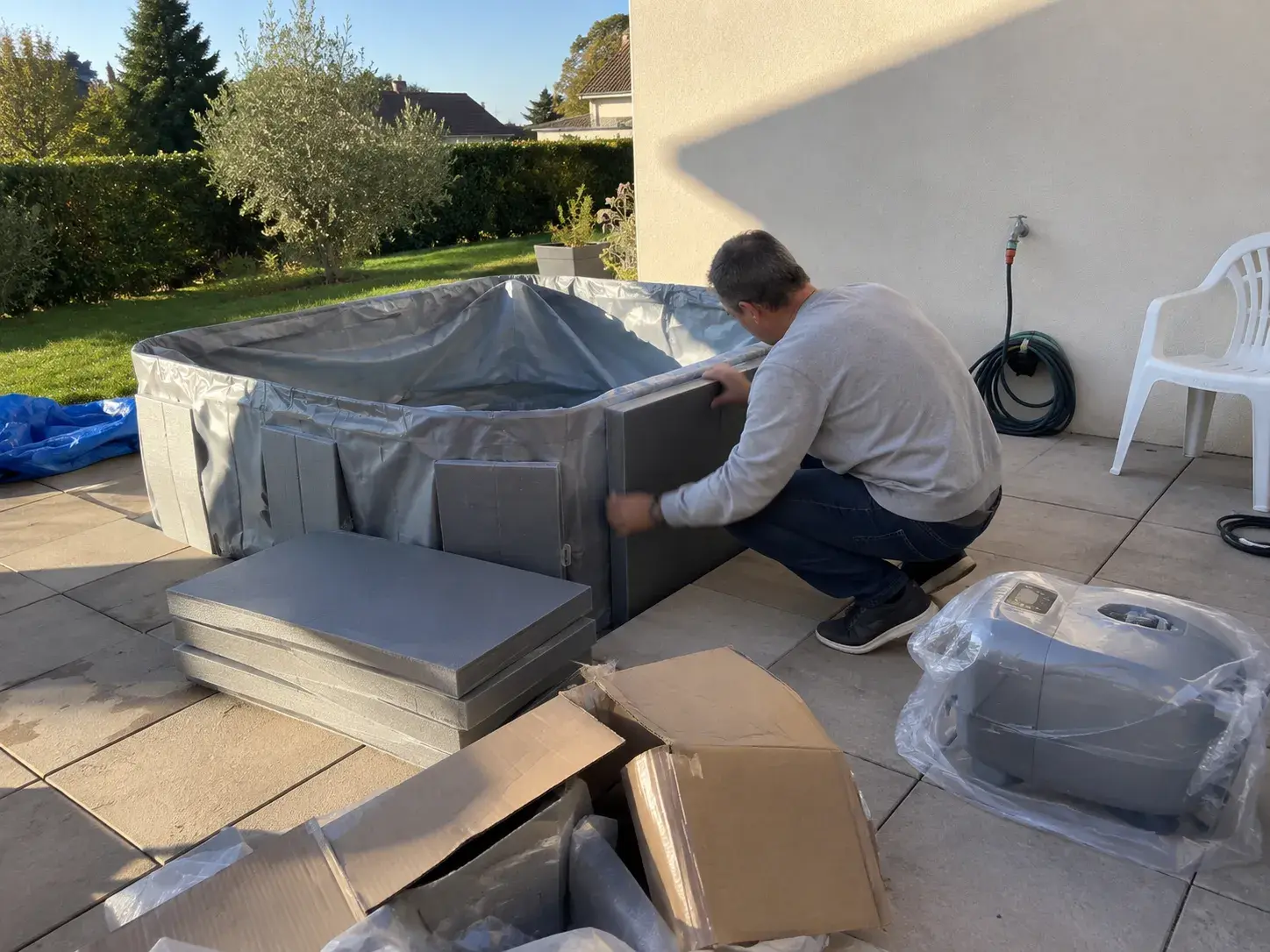 Un panneau de mousse glissé dans le liner d'un spa semi-rigide, sur la terrasse