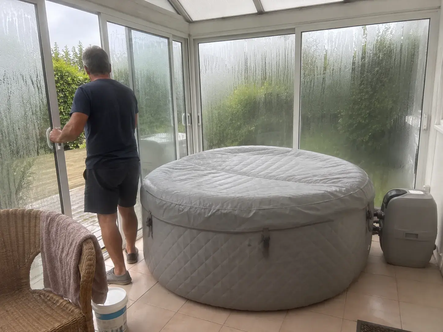 Les vitres d'une véranda couvertes de buée autour d'un spa gonflable, une baie qu'on ouvre