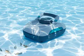Un robot de fond posé au fond d'un bassin ensoleillé, des feuilles mortes à côté de lui