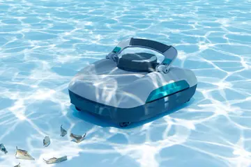 Un robot de fond posé au fond d'un bassin ensoleillé, des feuilles mortes à côté de lui