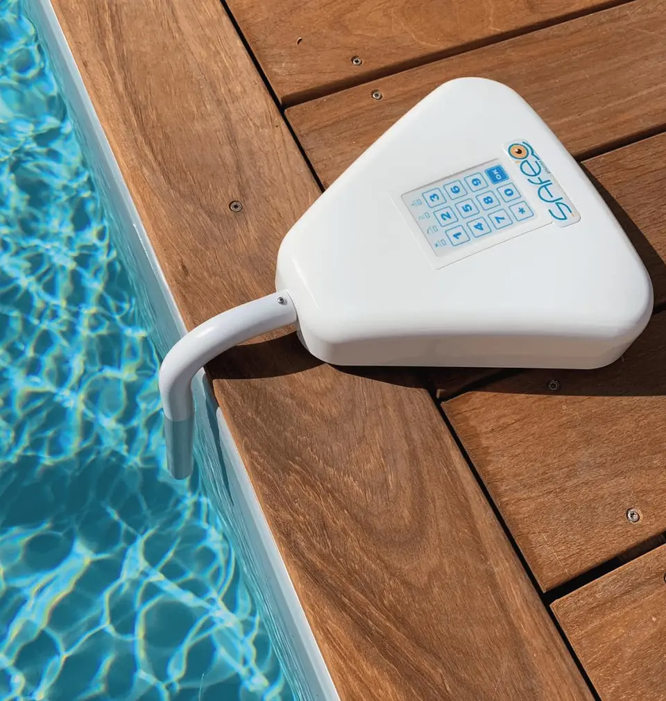 Alarme de piscine Safe'O, le boîtier à clavier et sa canne au bord du bassin, vue de trois quarts